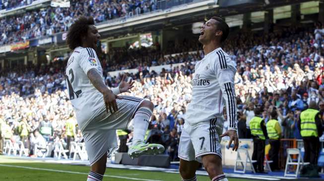 Cristiano Ronaldo merayakan gol kelimanya ke gawang Granda dengan rekan setimnya, Marcelo di  Santiago Bernabeu (5/4). REUTERS/Juan Medina