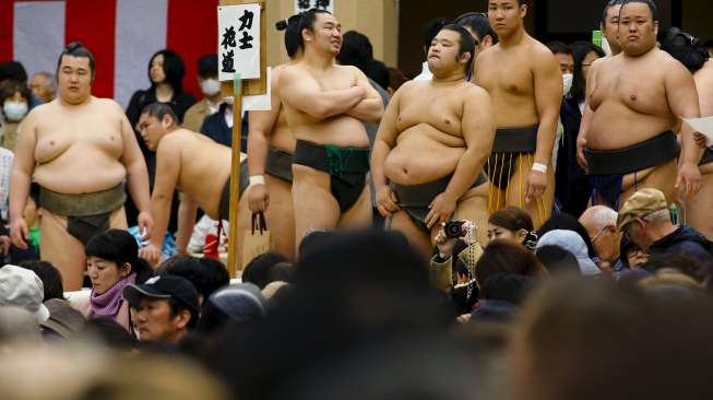 Para pesumo berkumpul di Kuil Yasukuni, Tokyo, Jepang, Jumat (3/4/2015). Para lelaki bertubuh besar yang hanya mengenakan celana ini ambil bagian dalam turnamen Sumo bertajuk Honozumo. [Reuters/Thomas Peter]