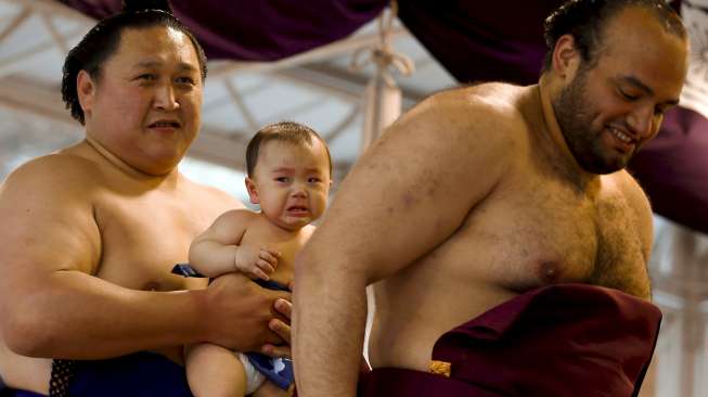 Para pesumo berkumpul di Kuil Yasukuni, Tokyo, Jepang, Jumat (3/4/2015). Para lelaki bertubuh besar yang hanya mengenakan celana ini ambil bagian dalam turnamen Sumo bertajuk Honozumo. [Reuters/Thomas Peter]