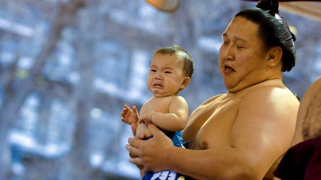 Para pesumo berkumpul di Kuil Yasukuni, Tokyo, Jepang, Jumat (3/4/2015). Para lelaki bertubuh besar yang hanya mengenakan celana ini ambil bagian dalam turnamen Sumo bertajuk Honozumo. [Reuters/Thomas Peter]