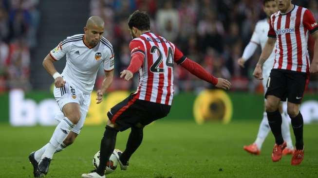 Pemain Valencia Sofiane Feghouli (kiri) mencoba menghadang pemain Athletic Bilbao Mikel Balenziaga di San Mames stadium,(9/4). [Reuters/Vincent West]