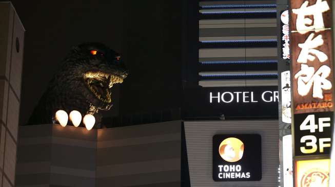 Sebuah replika kepala monster di film fiksi ilmiah, Godzilla, dipamerkan di atas balkon gedung kompleks perbelanjaan baru di distrik perbelanjaan dan hiburan Kabukicho, Tokyo, Jepang, (9/4/2015). [Reuters/Issei Kato]