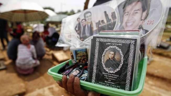 Pedagang berjualan cenderamata seperti mug, buku Surat Yasin, kalender, gantungan kunci, kaos dan pernak-pernik lain bergambar Olga Syahputra di TPU Malaka Duren Sawit Jakarta Timur, Jumat (10/4).[Suara.com/Kurniawan Mas'ud]