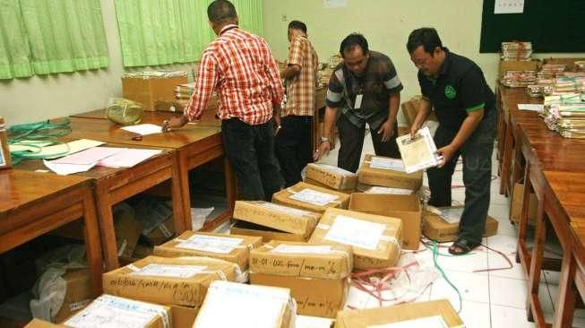 Sejumlah petugas tampak melakukan penyortiran soal Ujian Nasional (UN) saat tiba di SMAN 77, Jakarta Pusat, Sabtu (11/4/2015). [Suara.com/Kurniawan Mas'ud]