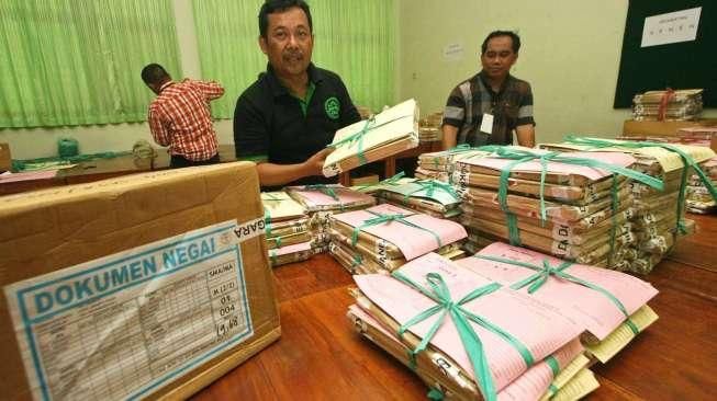 Sejumlah petugas tampak melakukan penyortiran soal Ujian Nasional (UN) saat tiba di SMAN 77, Jakarta Pusat, Sabtu (11/4/2015). [Suara.com/Kurniawan Mas'ud]