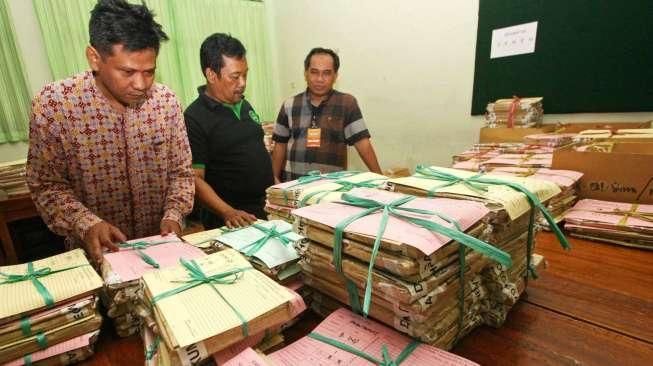 Sejumlah petugas tampak melakukan penyortiran soal Ujian Nasional (UN) saat tiba di SMAN 77, Jakarta Pusat, Sabtu (11/4/2015). [Suara.com/Kurniawan Mas'ud]