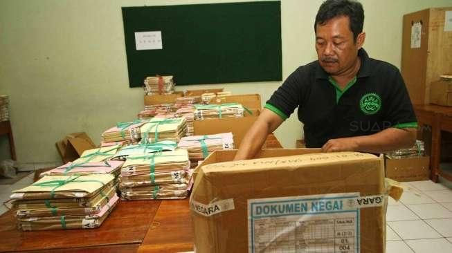 Sejumlah petugas tampak melakukan penyortiran soal Ujian Nasional (UN) saat tiba di SMAN 77, Jakarta Pusat, Sabtu (11/4/2015). [Suara.com/Kurniawan Mas'ud]