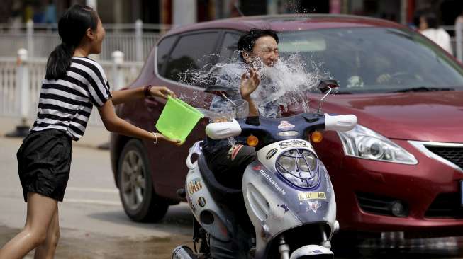 Ribuan orang ikut ambil bagian dalam festival semprot air di Xizhuangbanna, Jinghong, dan Menglian di Provinsi Yunnan, (15/4). [Reuters/Wong Campion/China Daily]