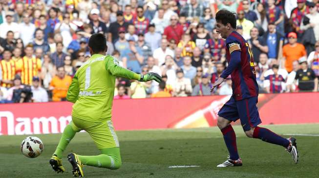 Pemain Barcelona Lionel Messi mencetak gol setelah menaklukkan kiper Valencia Diego Alves (kiri) di Camp Nou. Reuters/Gustau Nacarino