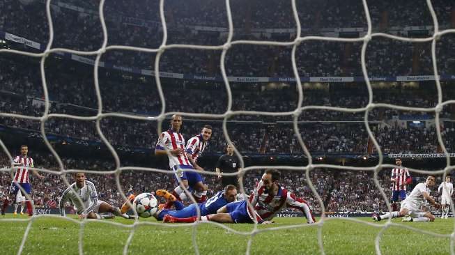 Pemain Real Madrid Javier Hernandez mencetak gol ke gawang Atletico (23/4) [Reuters/Juan Medina]