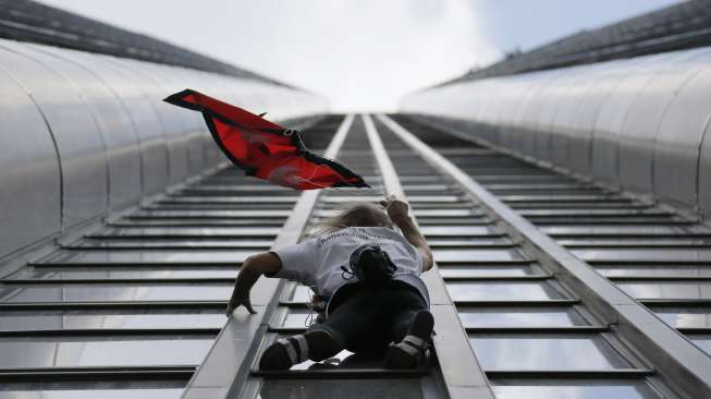 Pemanjat asal Prancis Alain Robert menaklukkan Tour Montparnasse. Gedung setinggi 210 meter di Paris, Prancis, Selasa (28/4).