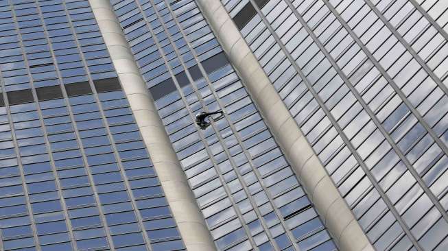 Pemanjat asal Prancis Alain Robert menaklukkan Tour Montparnasse. Gedung setinggi 210 meter di Paris, Prancis, Selasa (28/4).