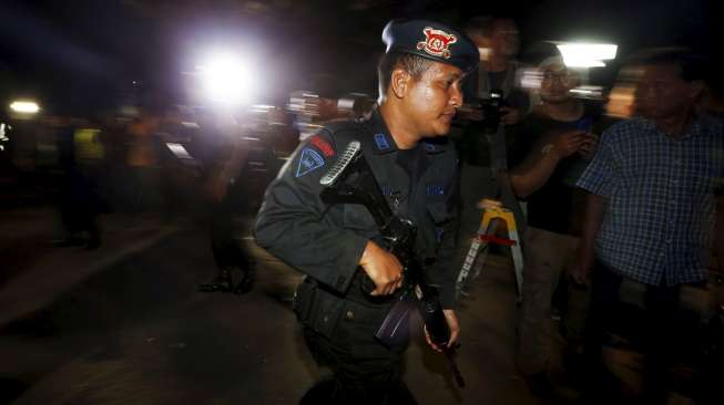 Seorang polisi berjaga di dermaga penyeberangan Wijaya Pura, Cilacap, Jateng, Rabu (29/4/2015) dini hari. (Reuters/Beawiharta)