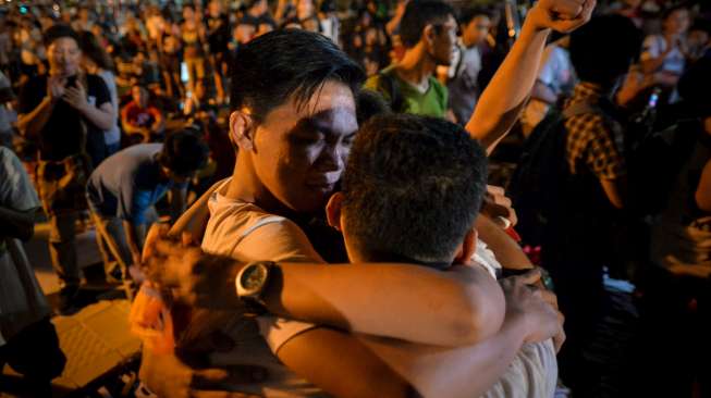 Aktivis Filipina berteriak kegirangan, berjingkrak dan berpelukan mengetahui penundaan eksekusi terhadap Mary Jane, hari Rabu (29/4/2015) dini hari di depan Kedubes Indonesia di Makati, Filipina. [Reuters/Ezra Acayan]