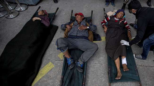 Beberapa korban cedera akibat gempa Nepal dibaringkan di atas tandu di Bandara Kathmandu, usai dievakuasi dari daerahnya masing-masing, Kamis (30/4/2015). [Reuters/Danish Siddiqui]