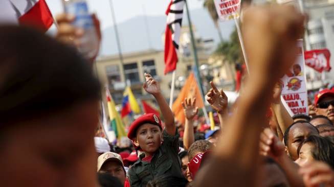 Para pendukung Presiden Venezuela Nicolas Maduro ikut serta dalam peringatan May Day di Caracas, (1/5). Maduro menaikkan upah minimum kaum buruh sebesar 30 persen. [Reuters/Jorge Silva]