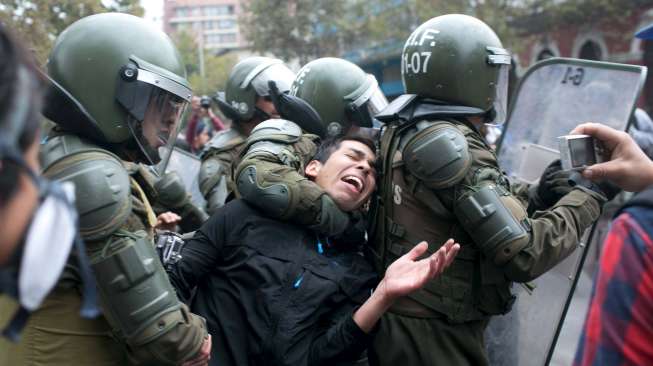 Seorang demonstran ditangkap polisi dalam demo May Day ricuh di Santiago, Chile, (1/5). [Reuters/Pablo Sanhueza]