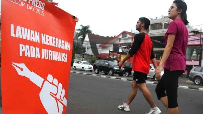 Memperingati Hari Kebebasan Pers Sedunia, AJI Indonesia membagi-bagikan selebaran tentang kebebasan pers kepada warga dan pengguna jalan di Taman Menteng, Jakarta Pusat, Minggu (3/5/2015). [Suara.com/Oke Atmaja]