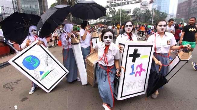 Sejumlah pelajar menggelar kampanye yang diwarnai aksi teatrikal di ajang Car Free Day (CFD) Jakarta, Minggu (3/5/2015), terkait reformasi pendidikan dan Hari Pendidikan Nasional yang jatuh pada 2 Mei. [Suara.com/Oke Atmaja]