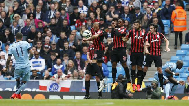 Pemain City Aleksandar Kolarov mencetak gol ke gawang QPR lewat tendangan bebas (11/5) [Reuters/Andrew Yates]