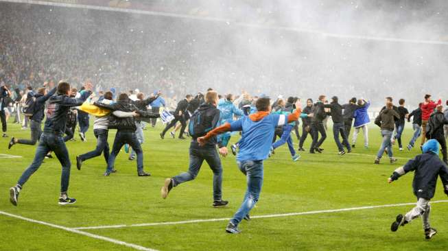 Para suporter berlari ke lapangan merayakan kemenangan Dnipro Dnipropetrovsk atas Napoli di semifinal Liga Europa. Reuters/Valentyn Ogirenko