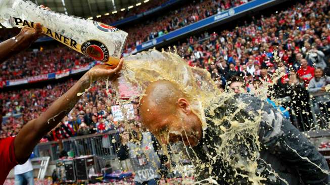 Pemain Bayern Munich David Alaba menuangkan beer ke kepala pelatih Pep Guardiola.  Reuters/Michael Dalder