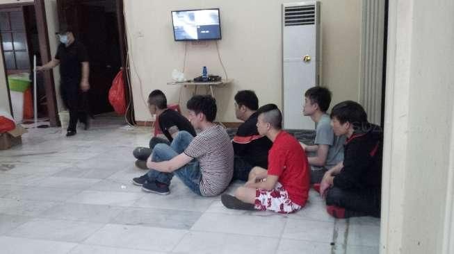 Sejumlah WNA beserta barang bukti terkait dugaan 'cyber crime' yang diamankan polisi di kawasan Kemang, Jakarta, Senin (25/5/2015) dini hari. [Suara.com/Erick Tanjung]