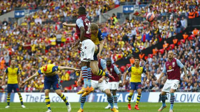 Per Mertesacker menanduk bola ke dalam gawang Aston Villa (31/5) [Reuters/Eddie Keogh]