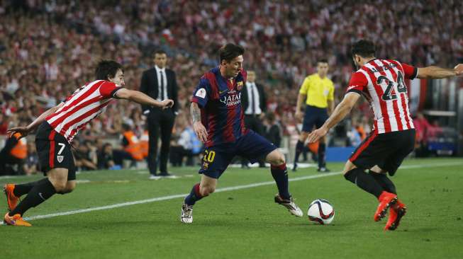 Lionel Messi mengecoh dua pemain Bilbao sebelum mencetak gol (31/5) [Reuters/Albert Gea]