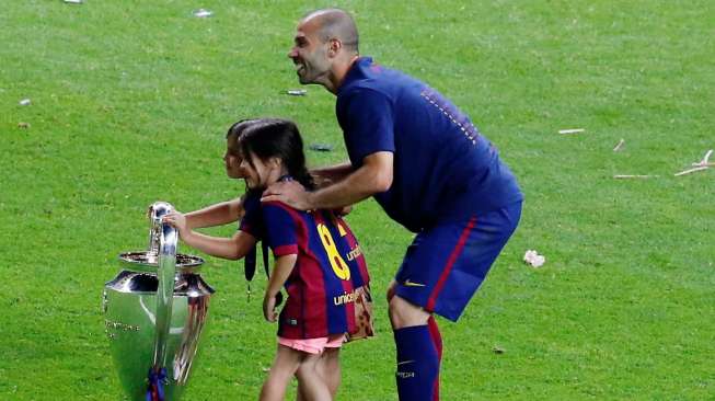 Pemain Barcelona Javier Mascherano berfoto dengan kedua anaknya dengan trofi Liga Champions. Reuters / Fabrizio Bensch