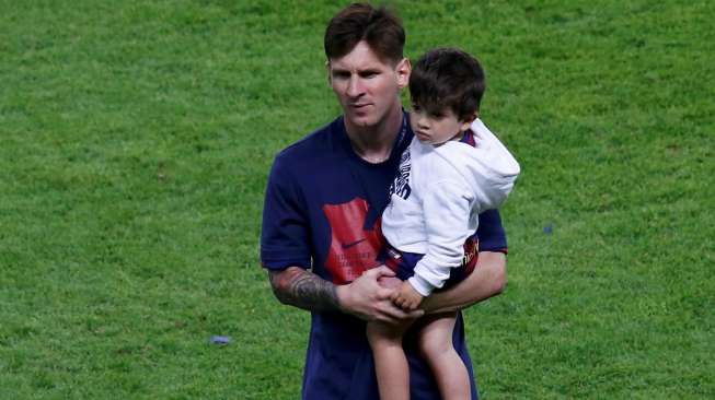 Bintang Barcelona Lionel Messi juga menggendong anaknya di lapangan merayakan kemenangan. Reuters/Fabrizio Bensch .