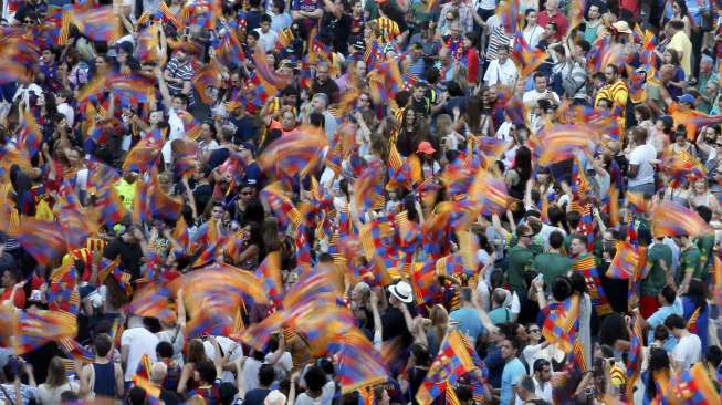 Fans Barcelona menyambut kepulangan tim kesayangan mereka usai memastikan trofi Liga Champions (8/6) [Reuters/Albert Gea]