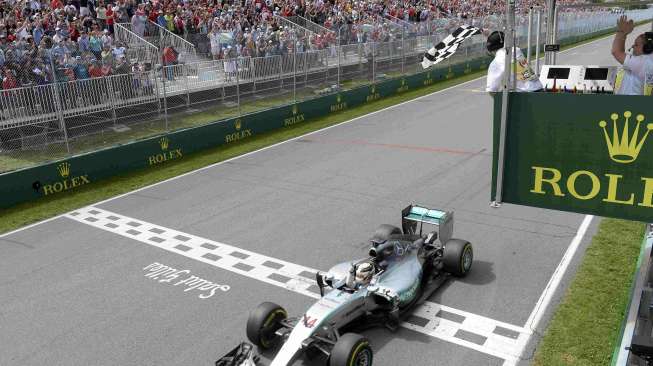 Pebalap Mercedes Lewis Hamilton melewati garis finis di GP Kanada, (7/6). [Reuters/Paul Chiasson]