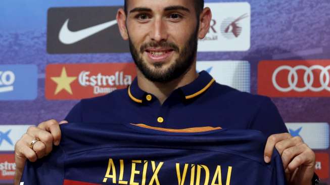 Pemain baru Barcelona Aleix Vidal berpose dengan jersey barunya di Camp Nou. Reuters/Albert Gea