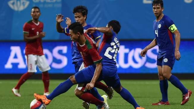 Pemain Indonesia Muchlis Hadi Ning Syaifulloh (tengah) mencoba melewati dua pemain Filipina. Antara Foto/Wahyu Putro