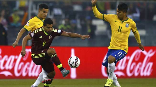 Pemain Venezuela Jose Rondon berebut bola dengan Pemain Brasil Philippe Coutinho dan Roberto Firmino (22/6) [Reuters/Ivan Alvarado]