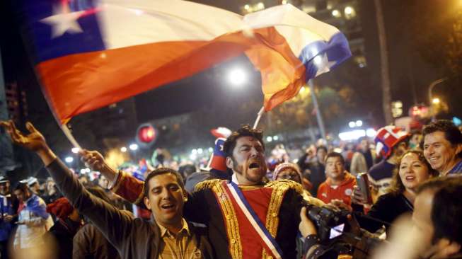 Para Fans Cile merayakan kemenangan skuatnya  atas Uruguay di Santiago (25/6). Reuters/Pablo Sanhueza.