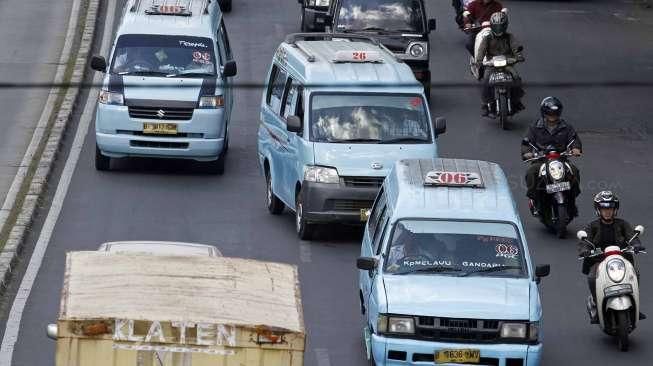 Angkutan kota (angkot) melintas di kawasan terminal Kampung Melayu, Jakarta Timur, Jumat (26/6). [suara.com/Kurniawan Mas'ud]