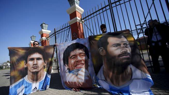 Fans Argentina membawa lukisan Lionel Messi (kiri) untuk mendukung Argentina (9/7) [Reuters]