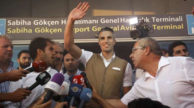 Robin van Persie menyapa para suporter Fenerbahce yang menyambutnya di bandara  Sabiha Gokcan, saat tiba di Istanbul, Turki (12/7). Reuters/Osman Orsal.