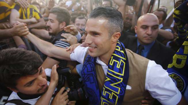 Robin van Persie menyapa para suporter Fenerbahce yang menyambutnya di bandara  Sabiha Gokcan, saat tiba di Istanbul, Turki (12/7). Reuters/Osman Orsal.