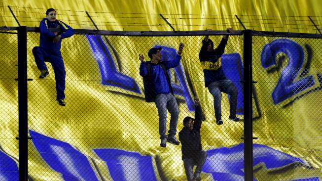 Beberapa fans Boca Juniors menaiki pagar pembatas La Bombonera Stadium saat Carlos Tevez diperkenalkan. Reuters/Marcos Brindicci