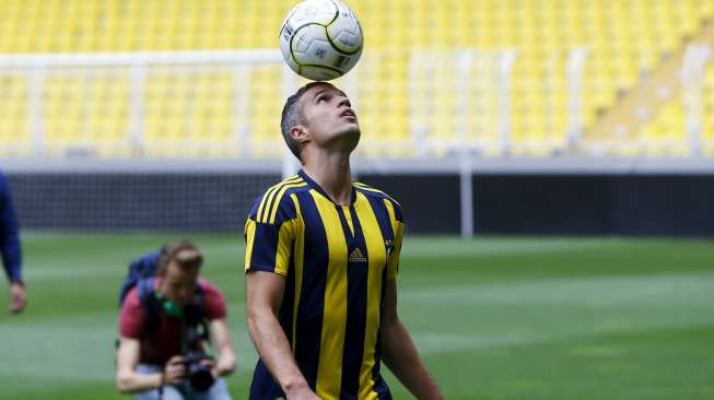 Pemain baru Fenerbahce Robin van Persie memainkan bola saat diperkenalkan di Sukru Saracoglu Stadium (14/7). Reuters/Osman Orsal