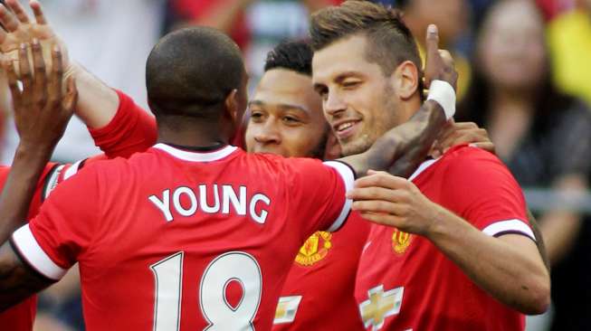 Pemain baru Manchester United Morgan Schneiderlin (kanan) merayakan golnya dengan  Ashley Young (kiri) dan Memphis Depay (tengah). Reuters / Anthony Bolante Livepic