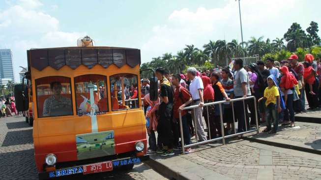 Ribuan warga menghabiskan waktu liburan di H+3 Lebaran di kawasan Monumen Nasional (Monas), Jakarta Pusat, Senin (20/7) [Suara.com/Oke Atmaja].