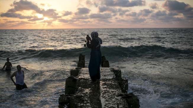 Masyarakat Palestina yang bermukim di Tepi Barat memadati pantai pesisir Laut Mediterania, (19/7), bertepatan dengan hari ketiga perayaan Hari Raya Idul Fitri 1436H. [Reuters/Baz Ratner]