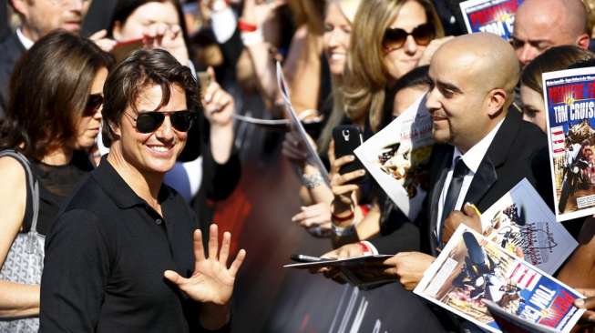 Tom Cruise menyapa dan berfoto bersama para penggemar saat tiba di acara pemutaran perdana film terbarunya yang berjudul Mission Impossible - Rogue Nation di Wina, Austria, (23/7). [Reuters/Leonhard Foeger]