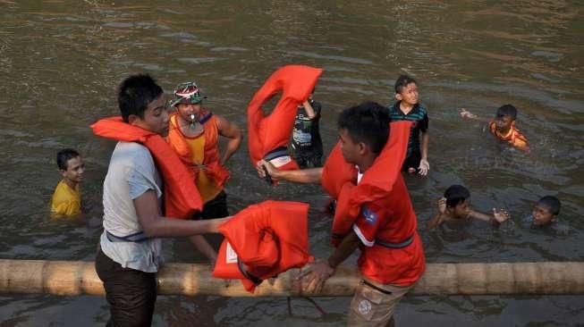 Ratusan warga mengikuti Pesta Rakyat Ciliwung di Jakarta, Sabtu (15/8). Acara tersebut digelar dalam rangka menyambut HUT ke-70 RI. [Suara.com/Kurniawan Mas'ud]