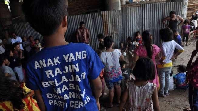 Masyarakat, termasuk anak-anak, mengikuti perayaan HUT Kemerdekaan Republik Indonesia yang ke-70 Tahun di kawasan kolong jembatan layang Lodan, Kampung Bandan, Jakarta, Senin (17/8). [Suara.com/Kurniawan Mas'ud]