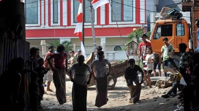 Masyarakat, termasuk anak-anak, mengikuti perayaan HUT Kemerdekaan Republik Indonesia yang ke-70 Tahun di kawasan kolong jembatan layang Lodan, Kampung Bandan, Jakarta, Senin (17/8). [Suara.com/Kurniawan Mas'ud]